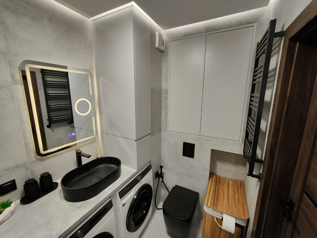 Płytki w łazience,grzejnik, suszarka, miska WC, umywalka, sufit podwieszany z Led, szafa wbudowana